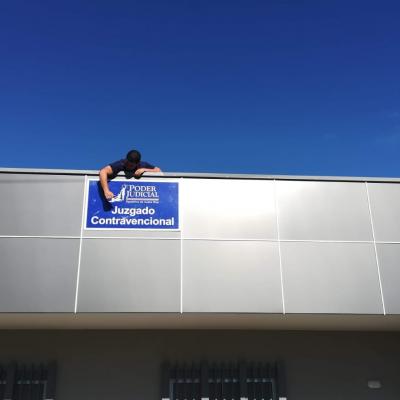 Persona colocando rotulo que dice juzgado contravencional