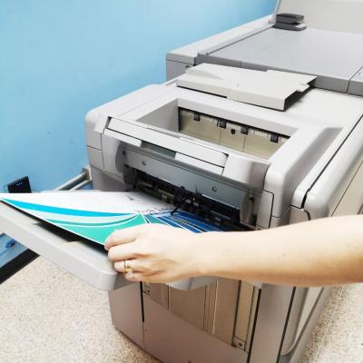 Persona poniendo un trozo de papel en una impresora