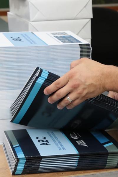 Persona acomodando libros sobre una mesa.